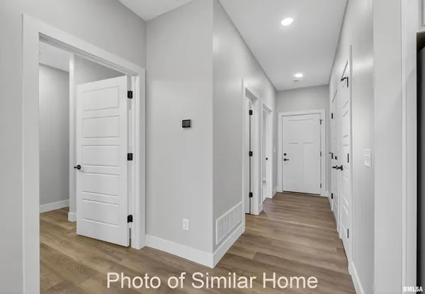 a view of a hallway with wooden floor and closet area