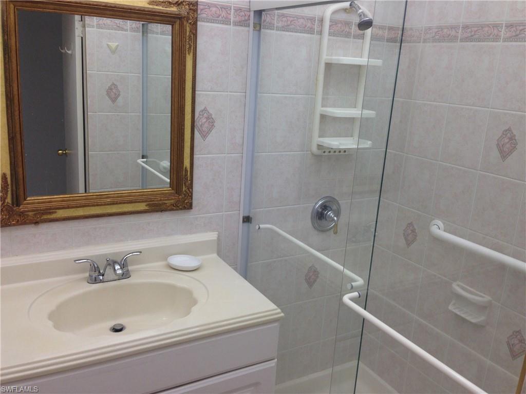 3760 Inverrary Drive, Unit 1W Lauderhill, FL 33319 - Photo 8 of 32 Bathroom featuring a tile shower and vanity