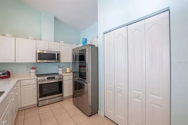 a kitchen with stainless steel appliances granite countertop white cabinets and refrigerator
