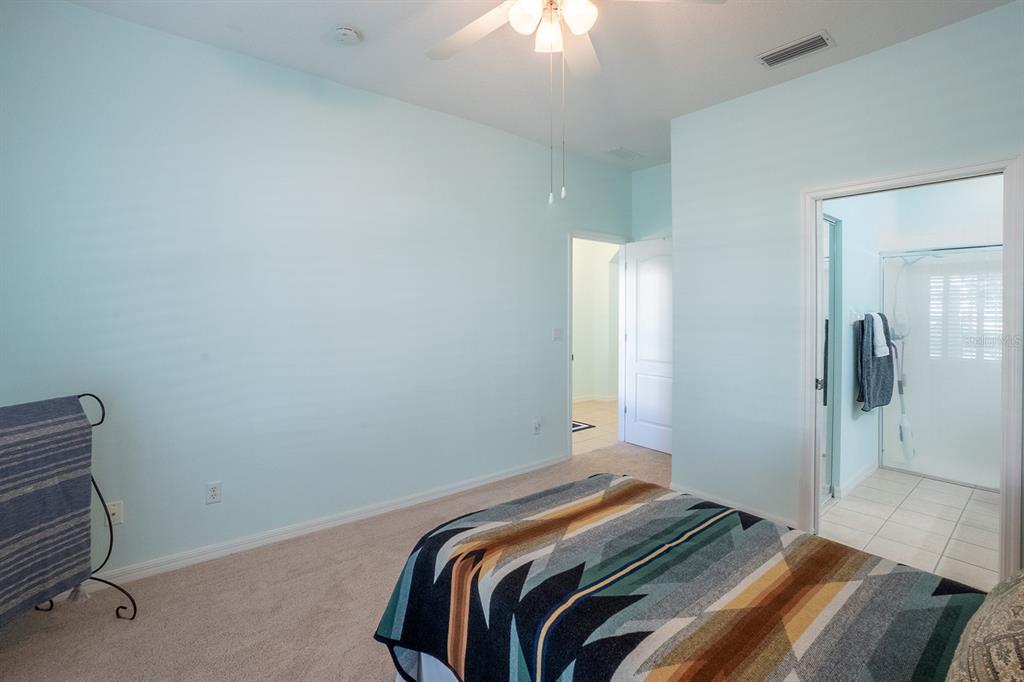 47 Summerwind Circle Palm Coast, FL 32137 - Photo 19 of 32 a bedroom with a bed and a chandelier