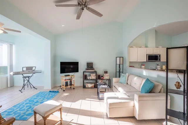 a living room with furniture a flat screen tv and kitchen view