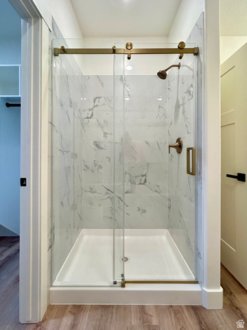 6 South 450th West Gunnison, UT 84634 - Photo 31 of 45 Shower enclosure featuring a sliding glass door, marble-look tile surround, bronze-finish hardware, and a white shower base