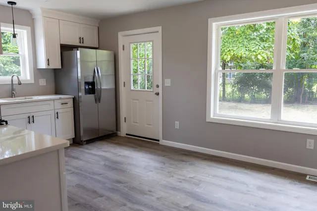 a kitchen with stainless steel appliances a refrigerator sink and window