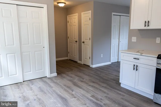 an empty room with wooden floor and cabinet