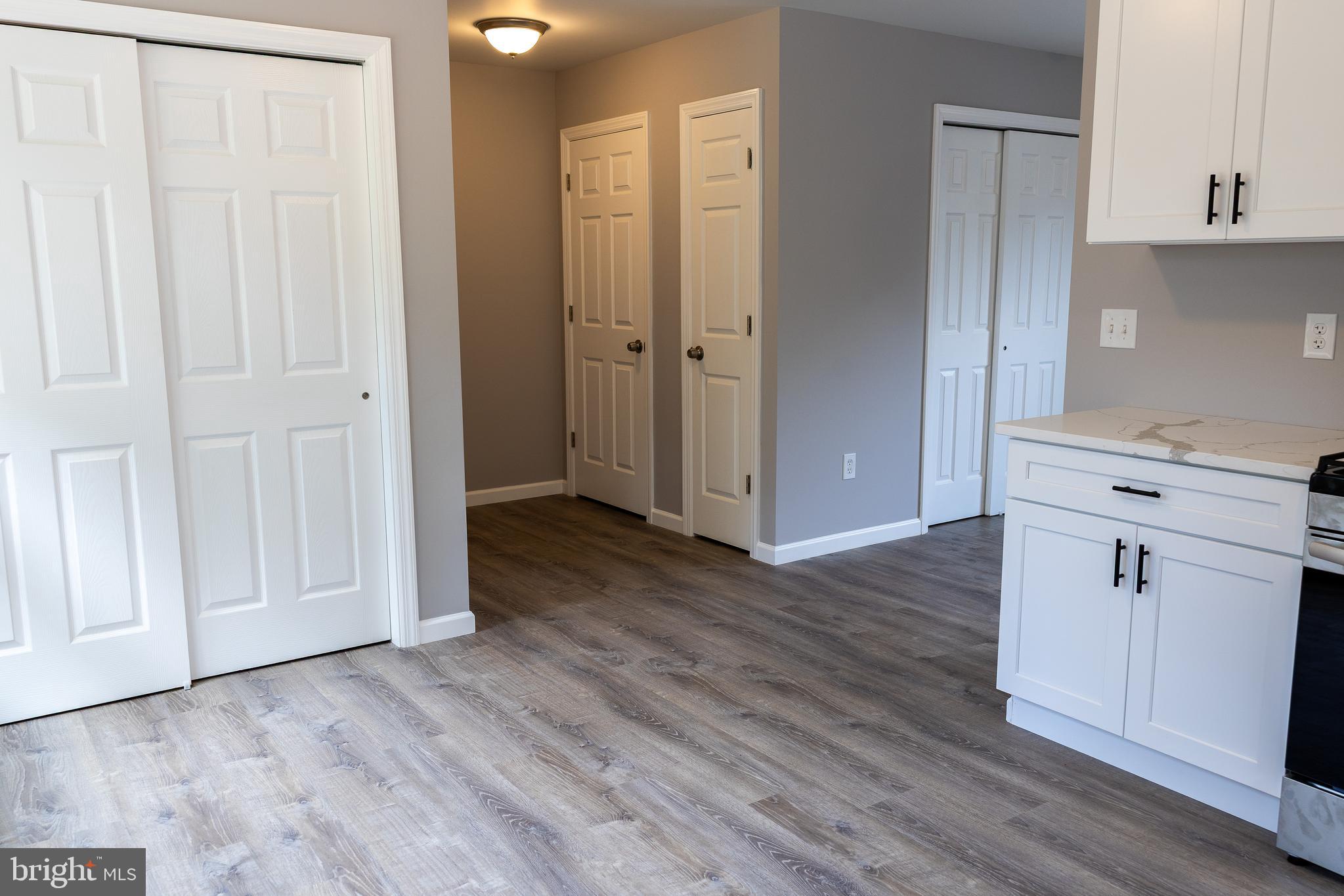 348 Colfax Street Bridgeton, NJ 08302 - Photo 8 of 26 an empty room with wooden floor and cabinet