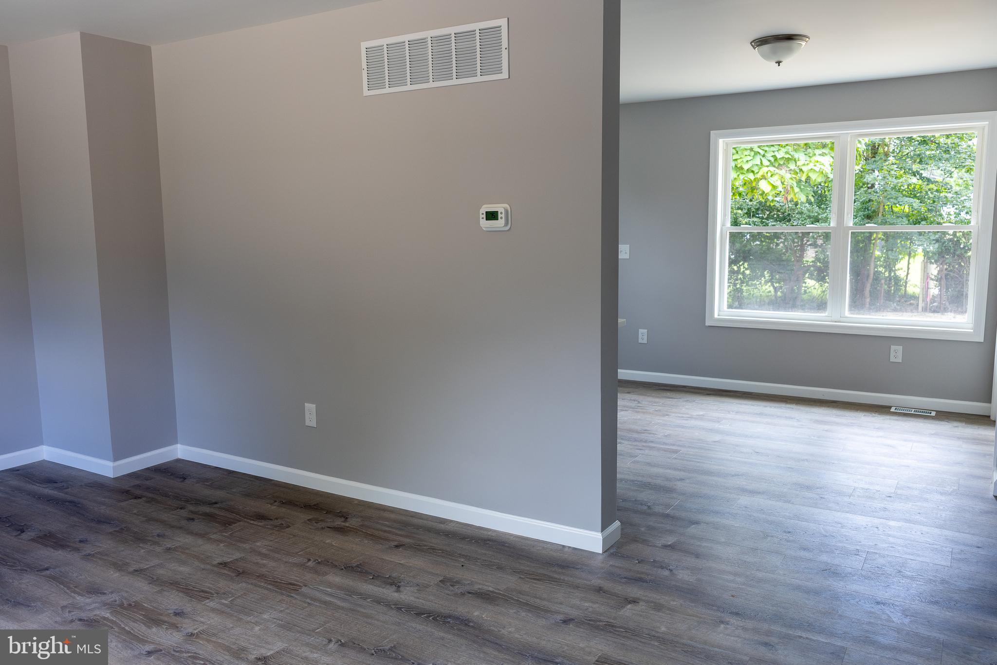 348 Colfax Street Bridgeton, NJ 08302 - Photo 10 of 26 an empty room with wooden floor and windows