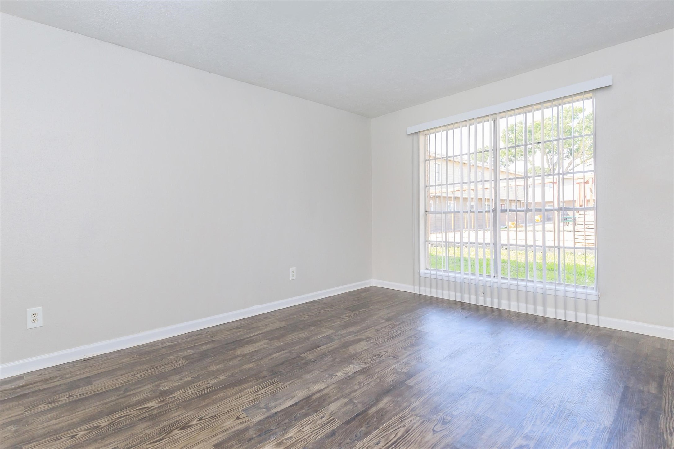 8271 Stone Street, Unit 7107 Houston, TX 77061 - Photo 2 of 28 a view of an empty room with wooden floor and a window