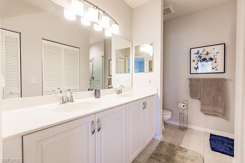 8135 Celeste Drive, Unit 4218 Naples, FL 34113 - Photo 24 of 37 Bathroom featuring tile patterned floors, toilet, and dual bowl vanity