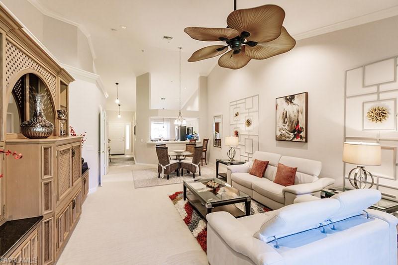 8135 Celeste Drive, Unit 4218 Naples, FL 34113 - Photo 4 of 37 Carpeted living room with crown molding, ceiling fan, and a towering ceiling