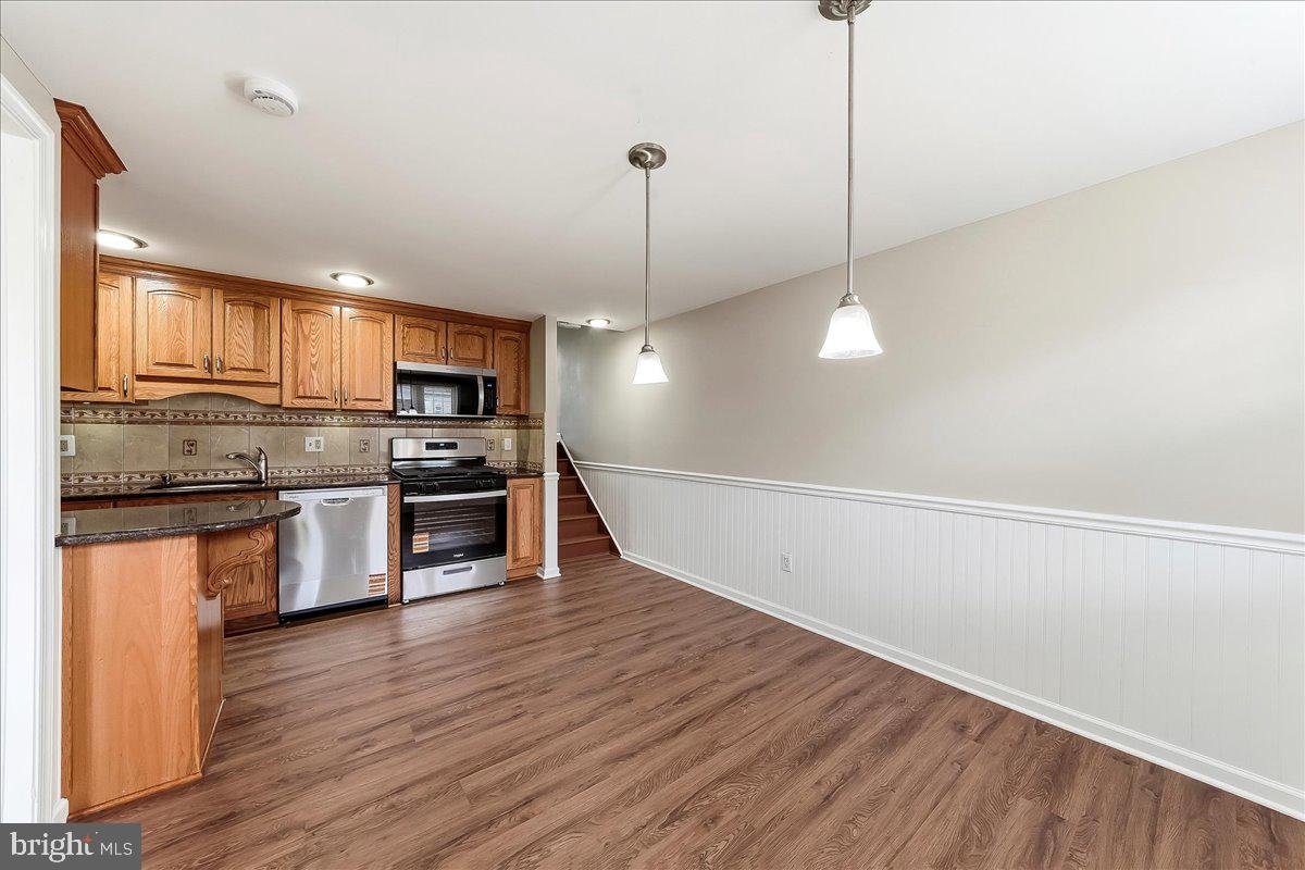 159 Chadwick Avenue Linwood, PA 19061 - Photo 11 of 35 a kitchen with stainless steel appliances granite countertop a sink a stove a refrigerator and wooden floor