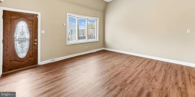 an empty room with wooden floor and a window