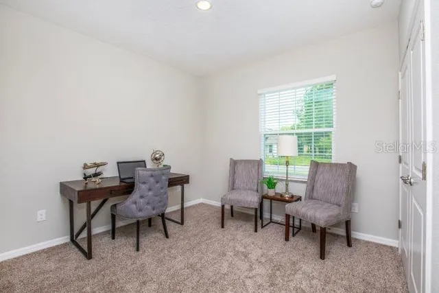a view of a workspace with furniture and a window