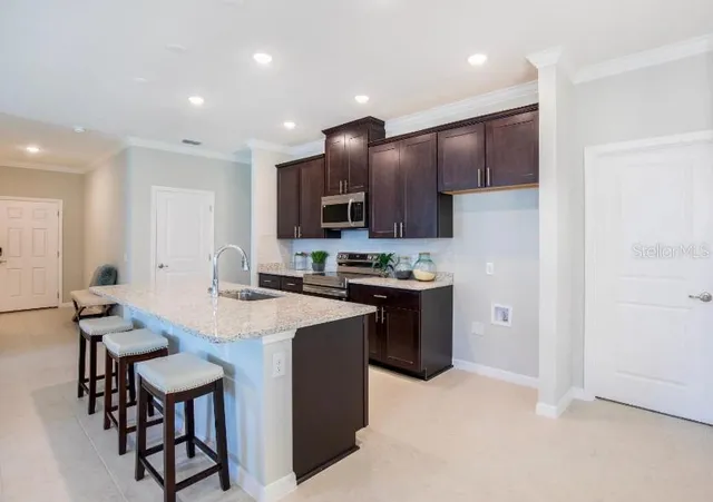 a kitchen with granite countertop a sink and a refrigerator