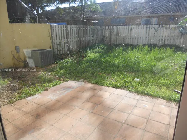 a backyard of a house with plants and tree
