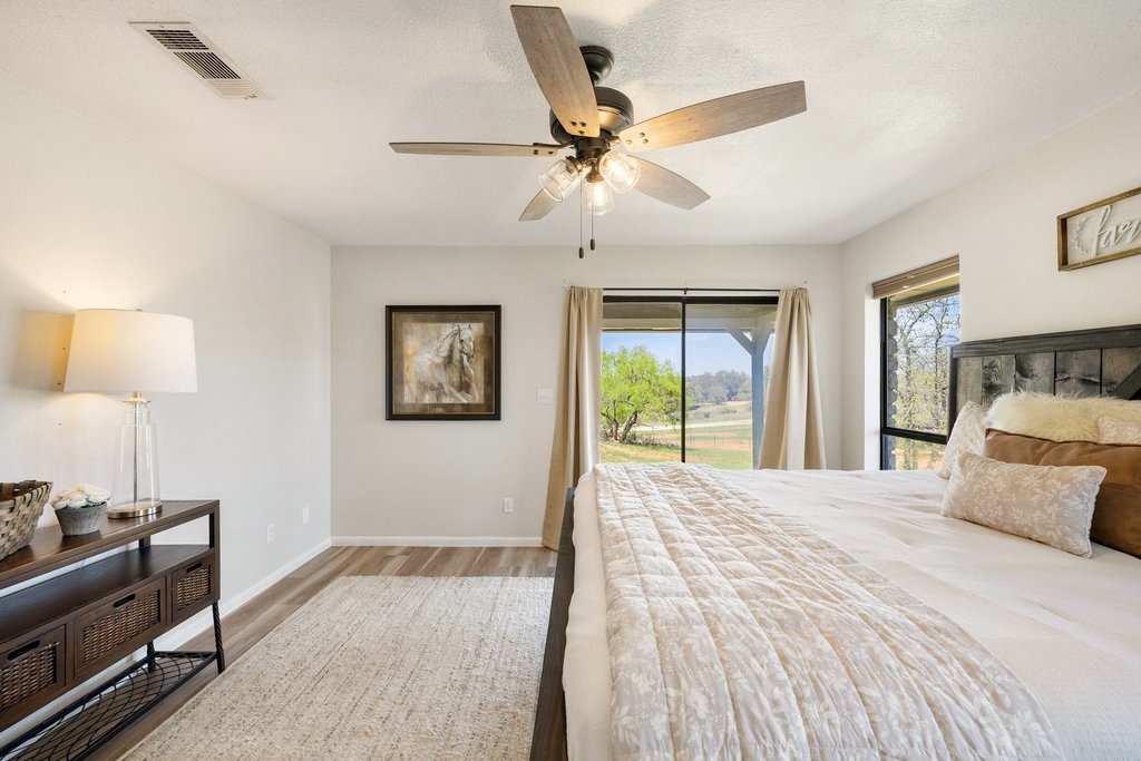 3410 West Ranch Road 152 Llano, TX 78643 - Photo 16 of 36 Bedroom featuring access to exterior, light wood-type flooring, and a ceiling fan