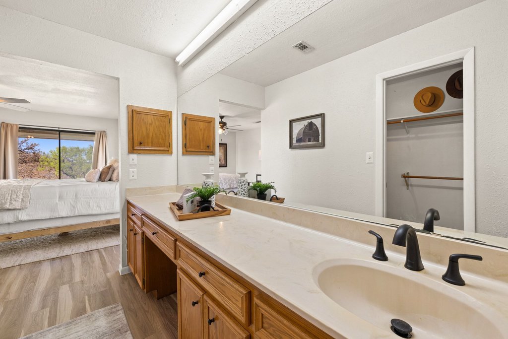 3410 West Ranch Road 152 Llano, TX 78643 - Photo 17 of 36 Ensuite bathroom with a ceiling fan, light wood-style floors, vanity, and a spacious closet