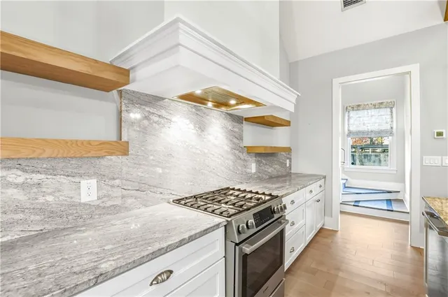 a kitchen with stainless steel appliances granite countertop a sink and a refrigerator