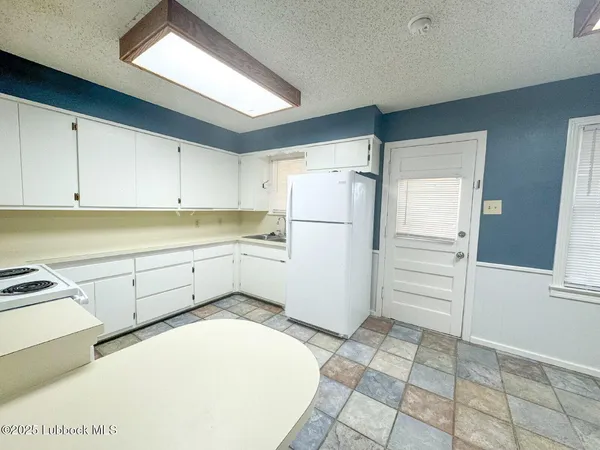 a kitchen with a refrigerator sink and cabinets