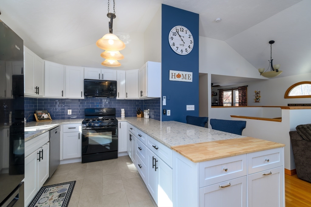 12 Hickory Road Millville, MA 01529 - Photo 17 of 41 a kitchen with kitchen island granite countertop a sink a stove oven a counter top space cabinets and stainless steel appliances