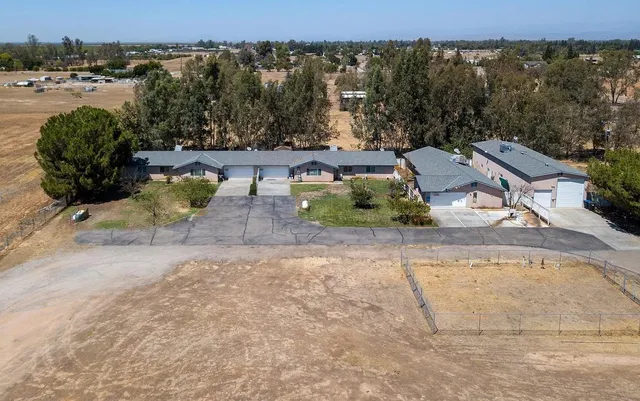 an aerial view of a house with a yard and lake view