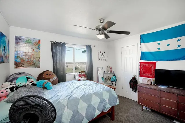 a bedroom with a bed dresser and flat screen tv