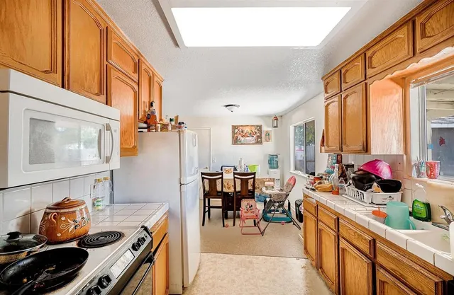a kitchen filled with a large window appliances and furniture