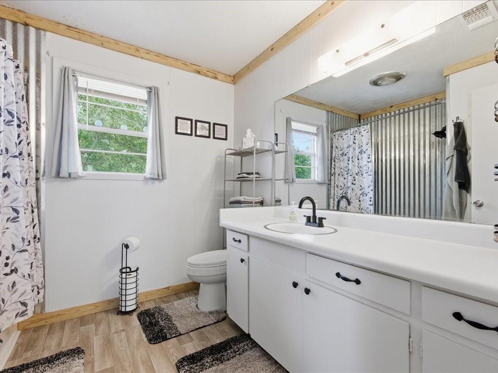 1085 Duke Road Kennard, TX 75847 - Photo 20 of 40 Bathroom featuring a white vanity with integrated sink, black hardware, and a large wall-mounted mirror
