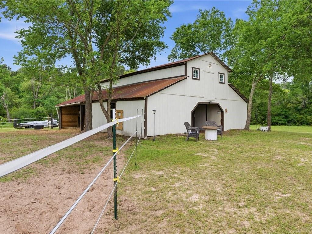 1085 Duke Road Kennard, TX 75847 - Photo 28 of 40 White barn structure featuring a brown metal roof, dual dormer windows, and a covered entry