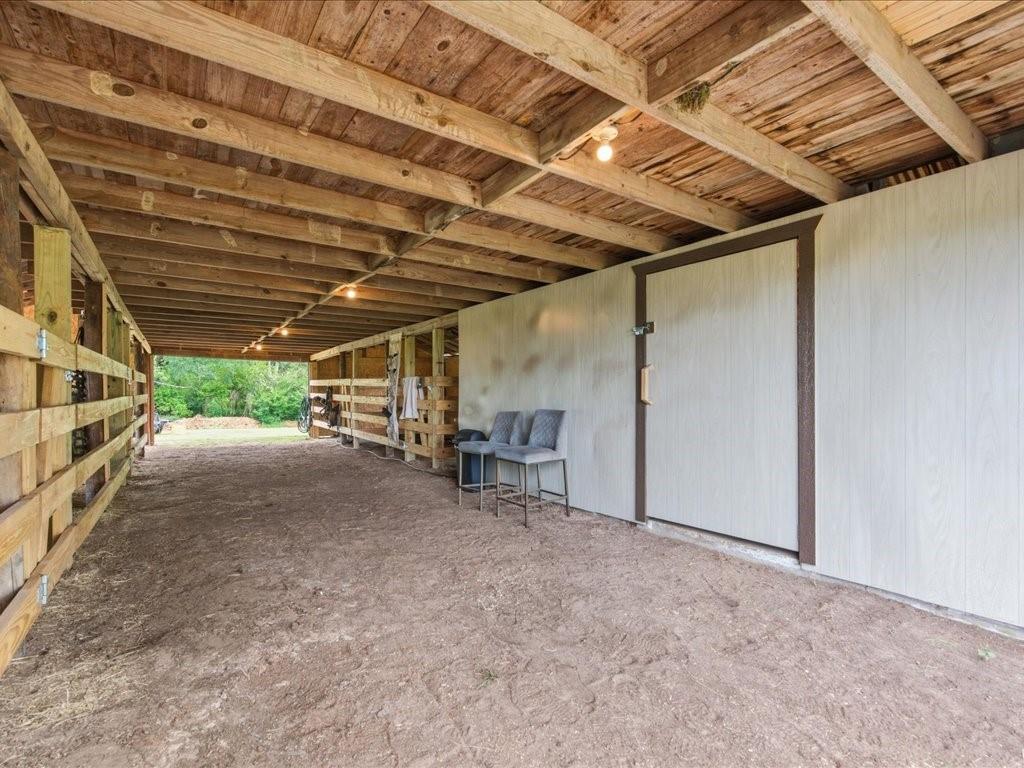 1085 Duke Road Kennard, TX 75847 - Photo 29 of 40 Open-air barn structure featuring exposed wood beam ceilings and wood-paneled walls
