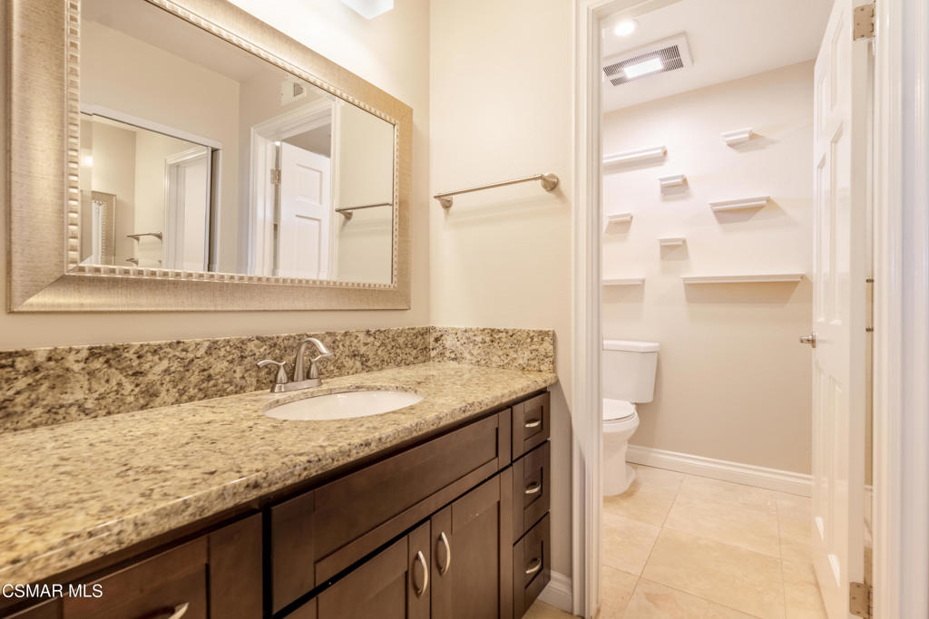 932 Thistlegate Road Oak Park, CA 91377 - Photo 13 of 25 a bathroom with a granite countertop sink a mirror and a shower
