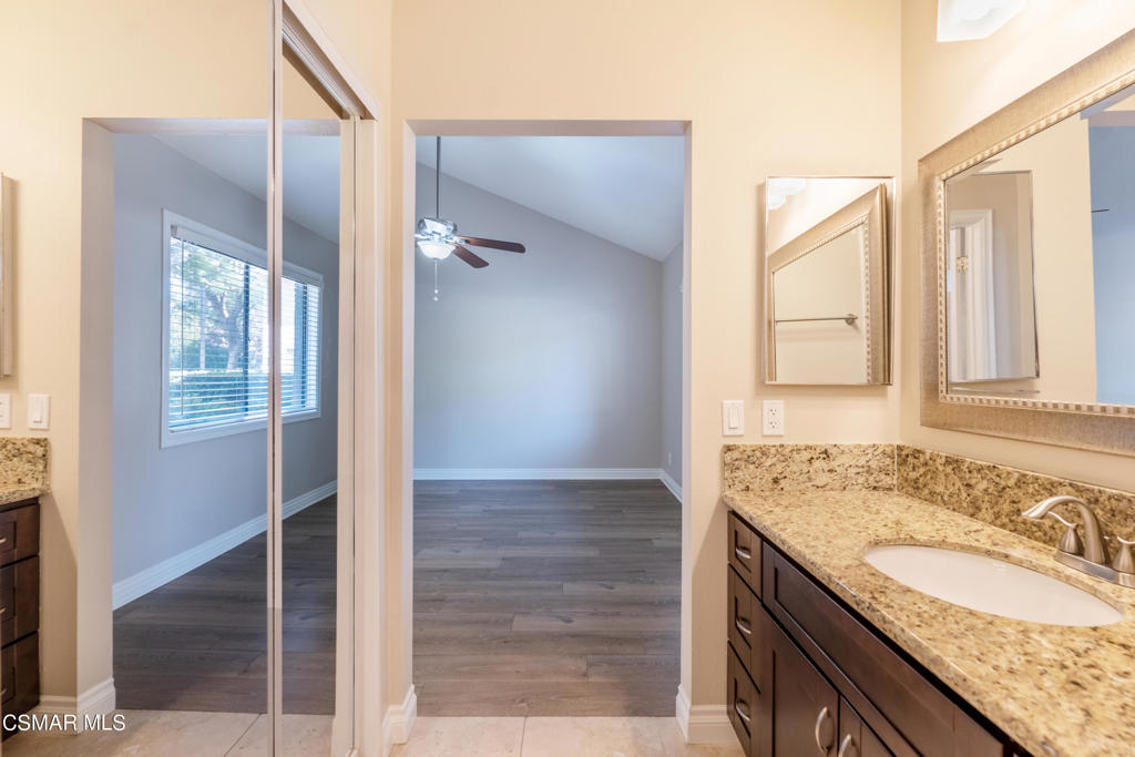 932 Thistlegate Road Oak Park, CA 91377 - Photo 15 of 25 a bathroom with a granite countertop sink and a mirror