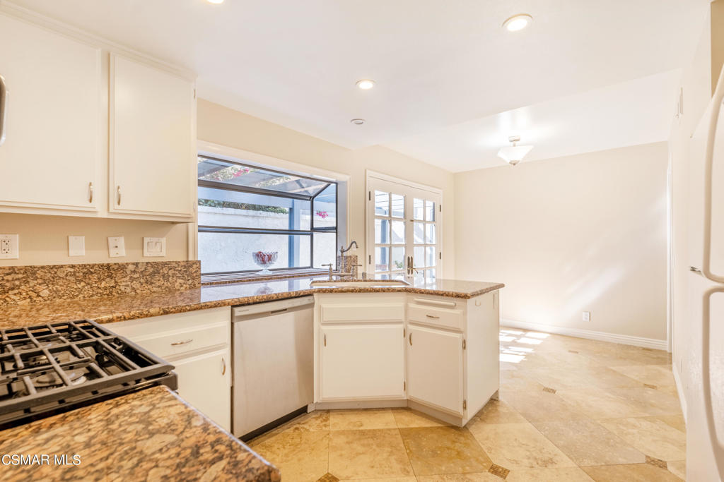 932 Thistlegate Road Oak Park, CA 91377 - Photo 10 of 25 a kitchen with stainless steel appliances granite countertop a stove a sink and a microwave