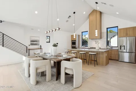 a kitchen with a dining table chairs sink and white cabinets