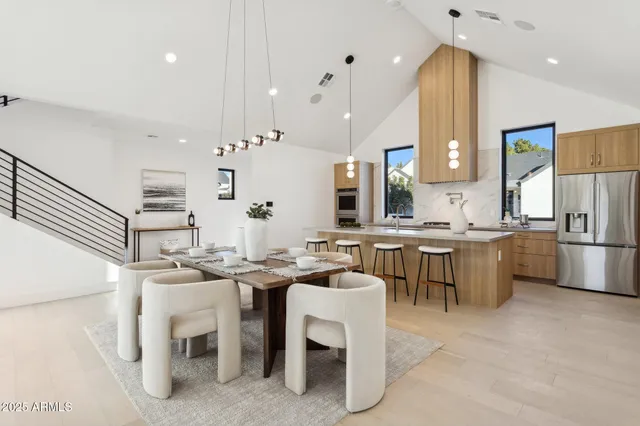 a kitchen with a dining table chairs sink and white cabinets