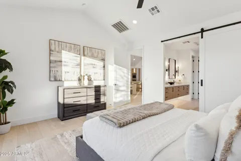 a bedroom with a large bed and a painting on the wall