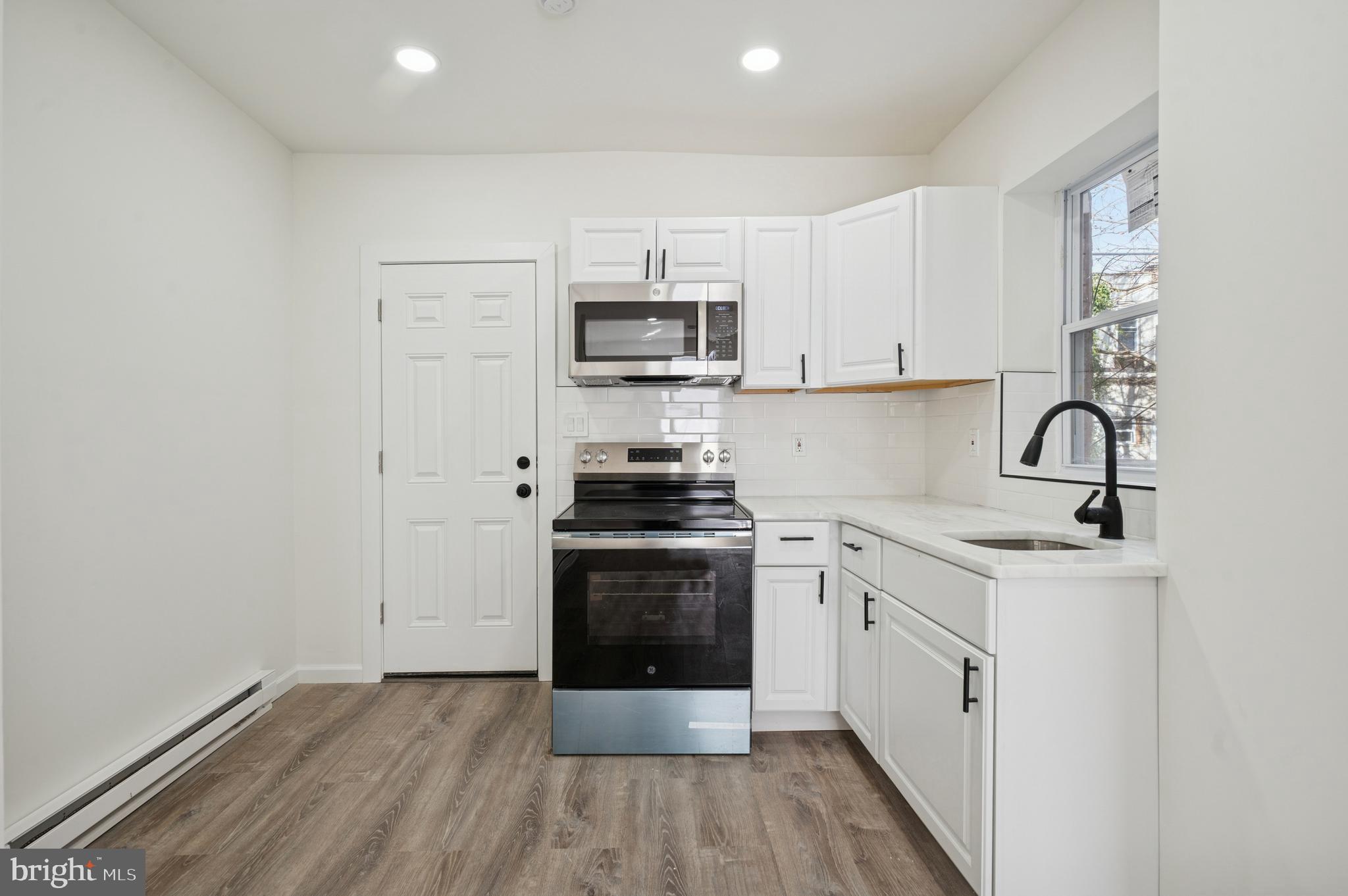 5929 Spring Street Philadelphia, PA 19139 - Photo 6 of 15 a kitchen with stainless steel appliances granite countertop a stove a sink and a refrigerator