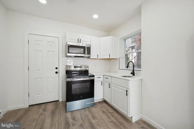 a kitchen with stainless steel appliances granite countertop a stove a sink and a microwave