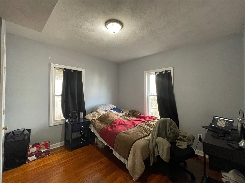 48 Derby Street, Unit 1 Somerville, MA 02145 - Photo 4 of 10 a bedroom with a bed and a tv