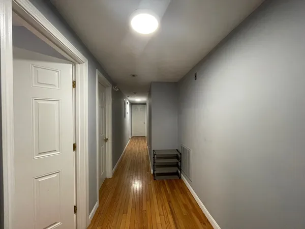 a view of a hallway with wooden floor and staircase