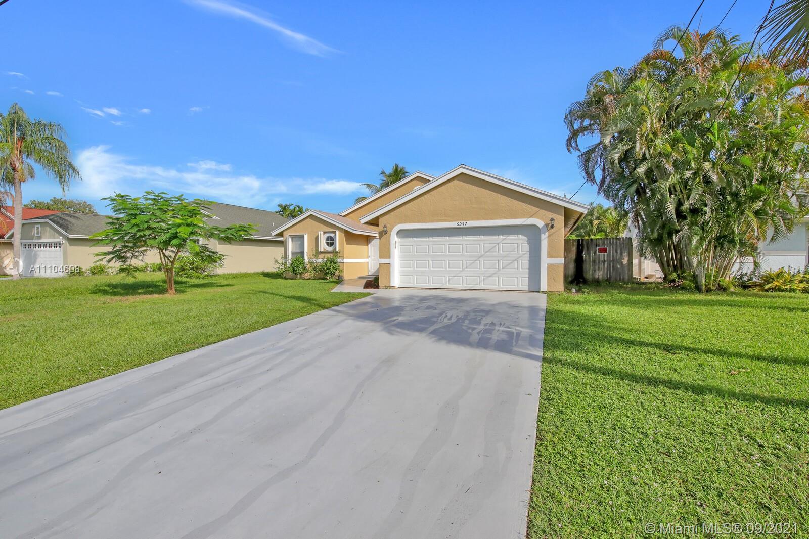 6247 Robinson Street Jupiter, FL 33458 - Photo 2 of 56 a front view of a house with a yard