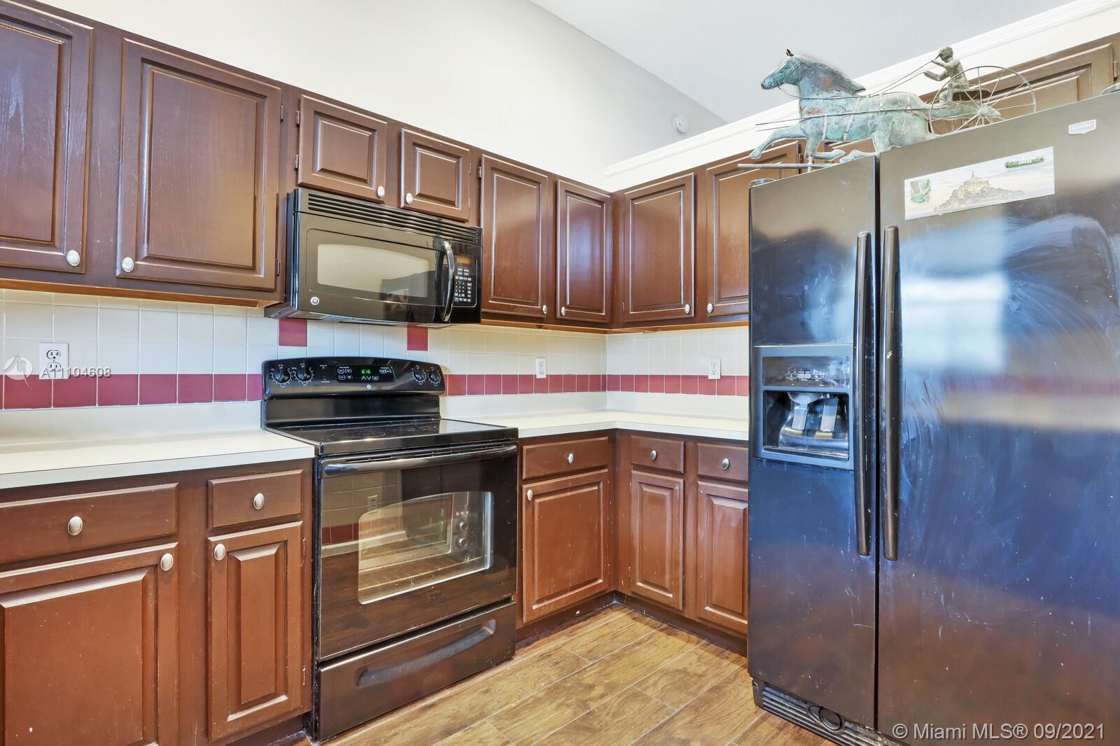 6247 Robinson Street Jupiter, FL 33458 - Photo 12 of 56 a kitchen with stainless steel appliances granite countertop a refrigerator and a stove top oven
