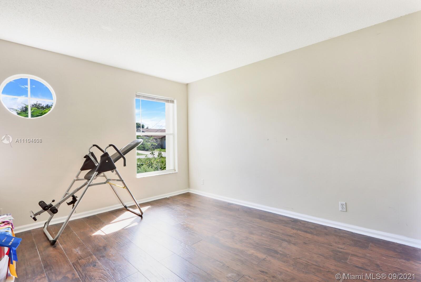 6247 Robinson Street Jupiter, FL 33458 - Photo 19 of 56 a room with gym equipment and a wooden floor