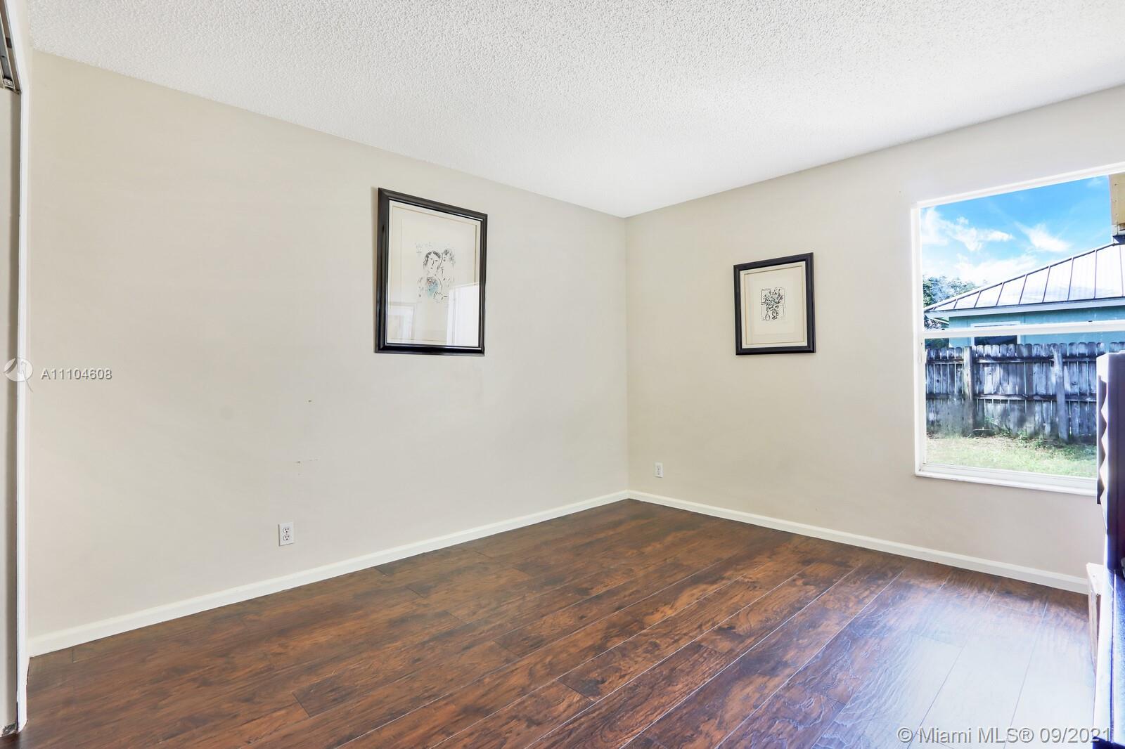 6247 Robinson Street Jupiter, FL 33458 - Photo 21 of 56 a view of an empty room with a window and wooden floor