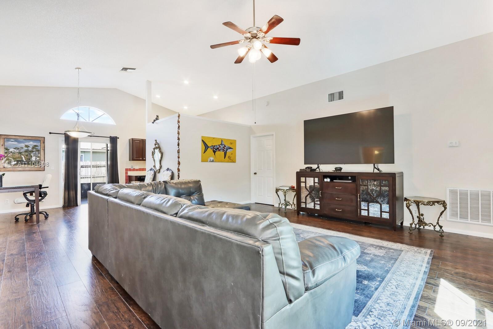 6247 Robinson Street Jupiter, FL 33458 - Photo 8 of 56 a living room with furniture and a flat screen tv with wooden floor