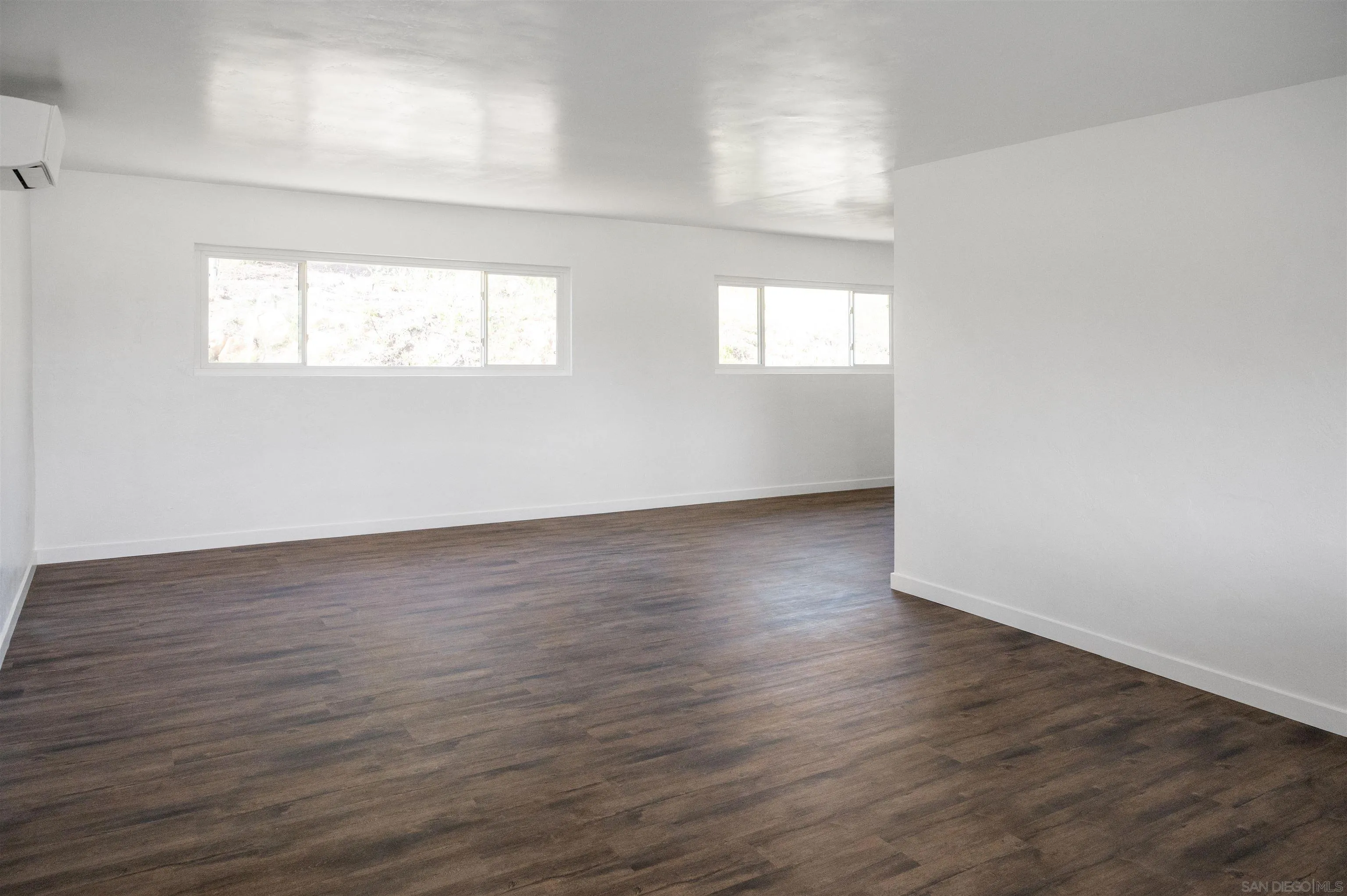 13504 Willow Road Lakeside, CA 92040 - Photo 7 of 9 an empty room with wooden floor and windows