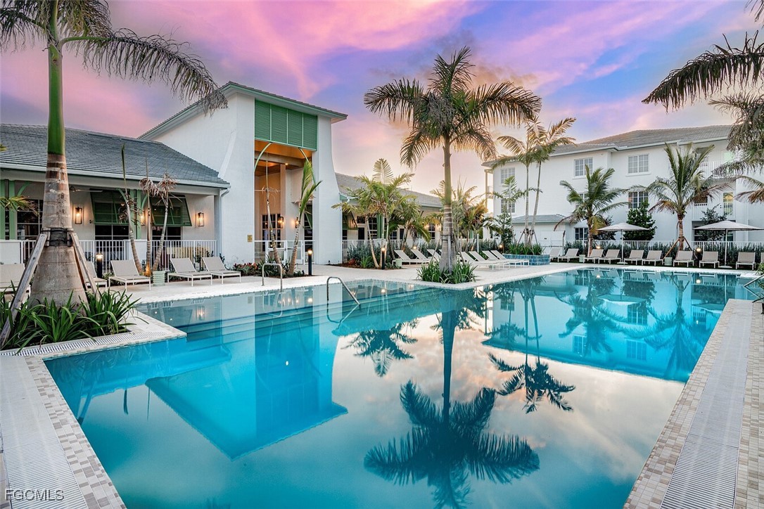 6026 Whitaker Road, Unit A1 Naples, FL 34112 - Photo 1 of 23 a swimming pool with outdoor seating and yard