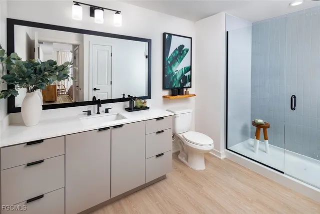 a bedroom with a bed and a flat tv screen on the dresser