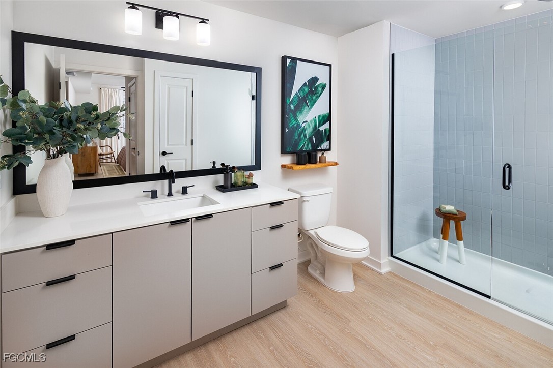 6026 Whitaker Road, Unit A1 Naples, FL 34112 - Photo 19 of 23 a bathroom with a toilet a sink and a mirror