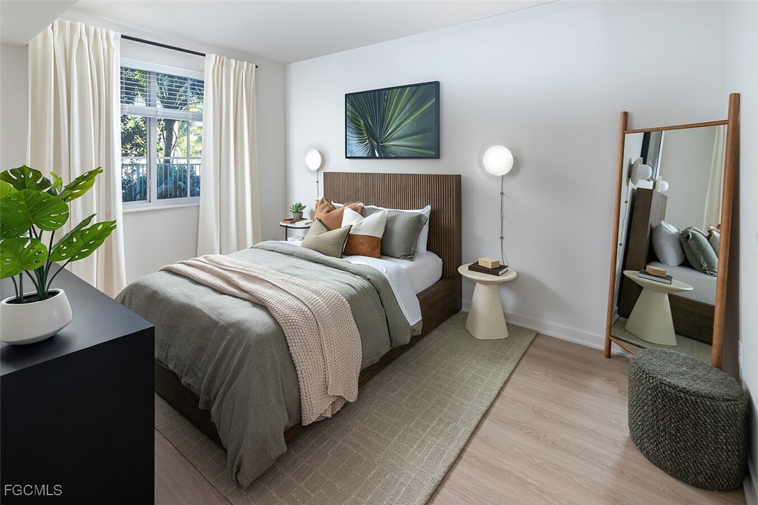 6026 Whitaker Road, Unit A1 Naples, FL 34112 - Photo 20 of 23 a bedroom with a bed and a flat tv screen on the dresser