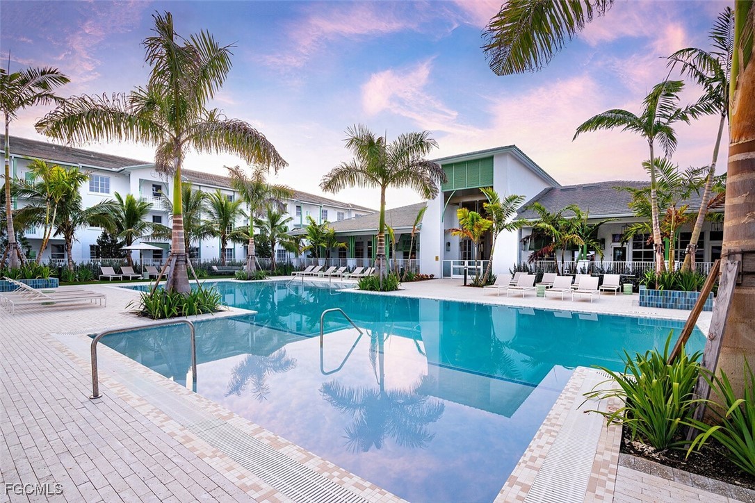 6026 Whitaker Road, Unit A1 Naples, FL 34112 - Photo 4 of 23 a view of a swimming pool with a table and chairs